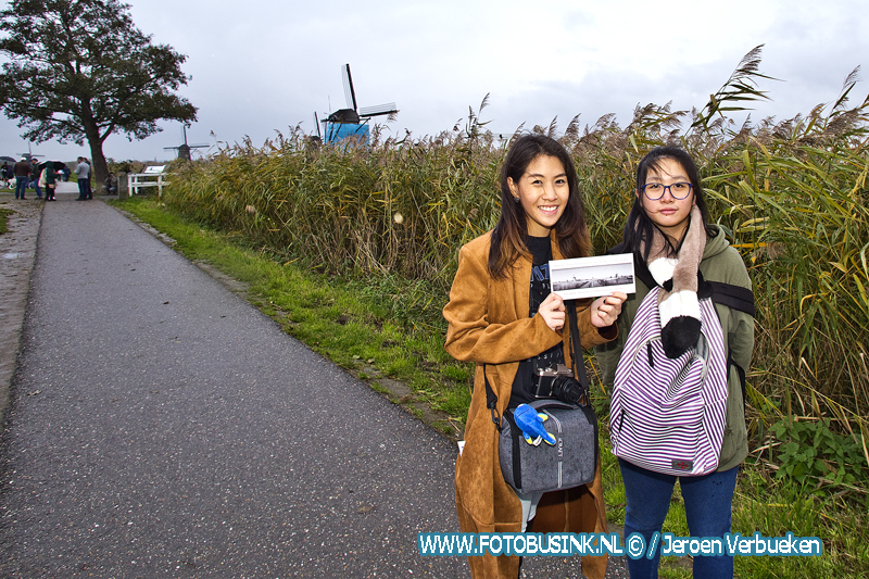 Molenbewoners Kinderdijk delen ansichtkaarten uit aan toeristen tegen overtoerisme.
