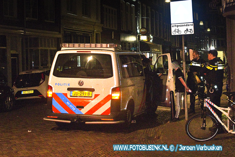 Man met glas gestoken aan de Voorstraat in Dordrecht.