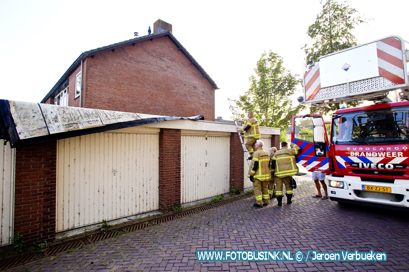 Dakbedekking laat los door harde wind van garage's aan de Schipbeekstraat in Dordrecht.