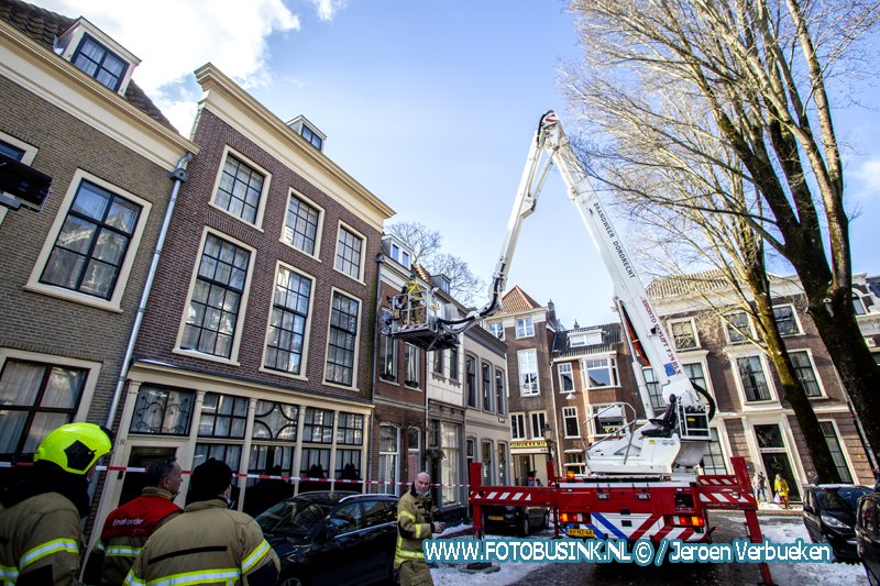 Brandweer verwijdert gevaarlijk hangende ijspegels in Dordrecht.