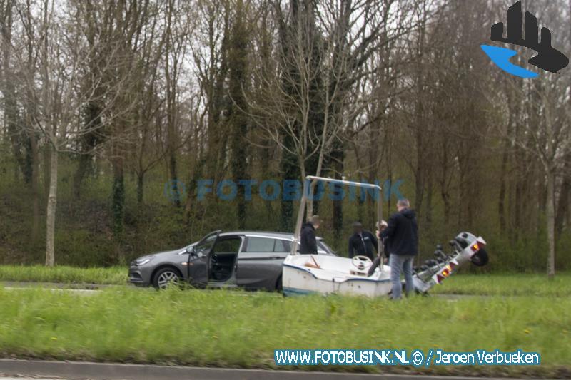 Omstanders helpen boot van de weg te halen aan de N217 in 's-Gravendeel