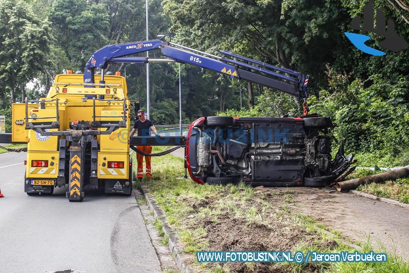 Auto op zijn kant op de Brugweg in Dordrecht