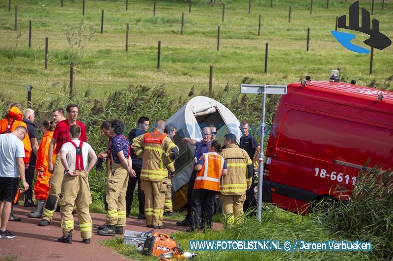Huifkar vol mensen te water aan de Wieldrechtse Zeedijk in Dordrecht