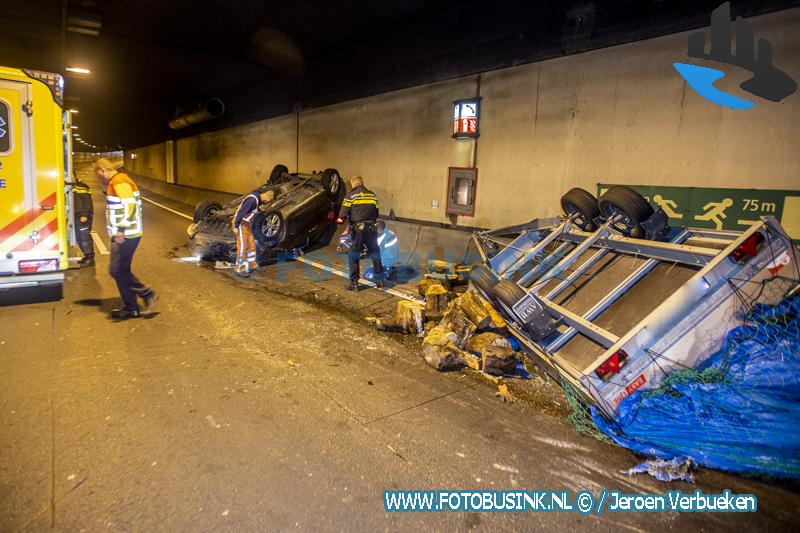 Auto met aanhanger vol houtblokken slaat over de kop in de Drechttunnel