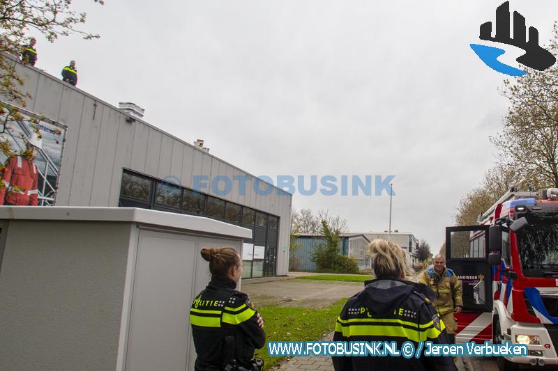 Brandweerlieden helpen agenten van het dak af van een bedrijfspand in Dordrecht