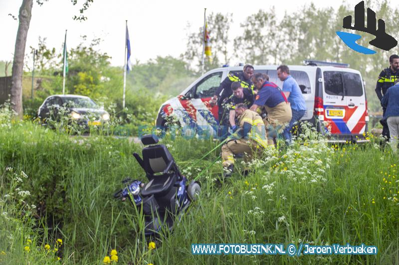 Man op scootmobiel te water aan de Oude Veerweg in Dordrecht