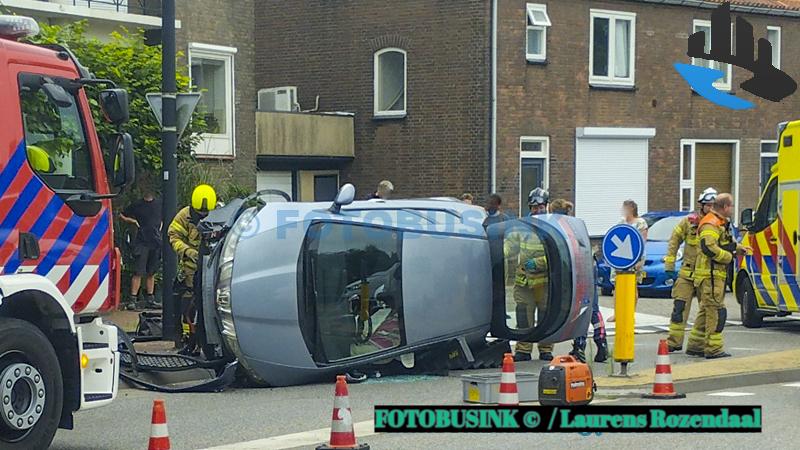 Auto op zijn kant op de Rivierdijk in Sliedrecht