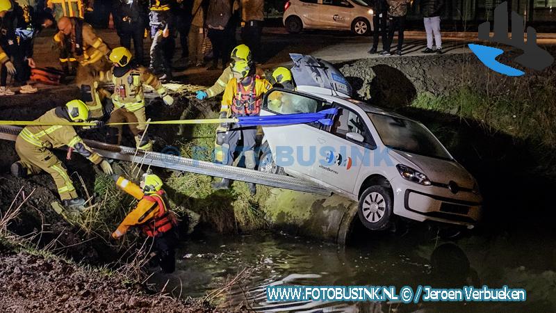 Hulpdiensten redden drie personen uit auto nadat de auto op een betonnen rioolbuis in het water was beland op de Kristalweg in Puttershoek